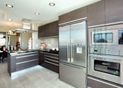 Thumbnail 6 of 29 - A modern kitchen with stainless steel appliances and a tile floor.